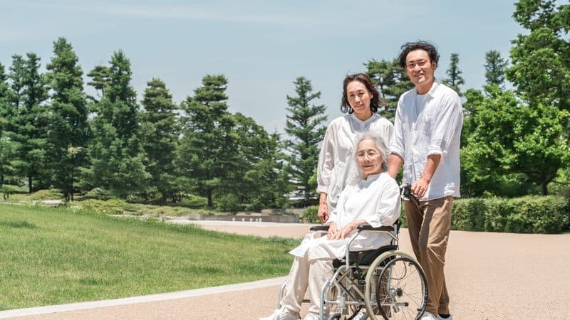 車椅子の親と付き添う家族